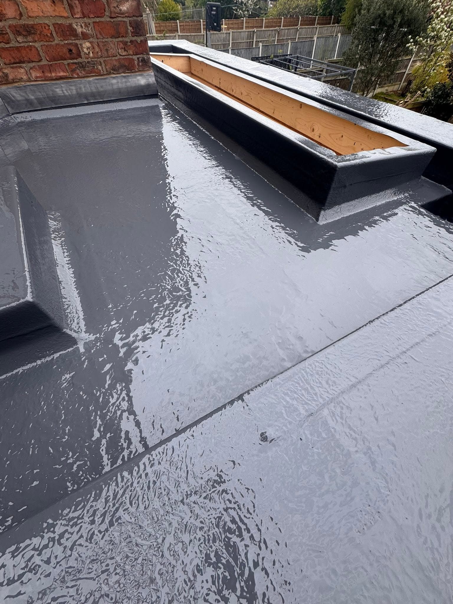 GRP flat roof dressed around a brick chimney and parapet wall