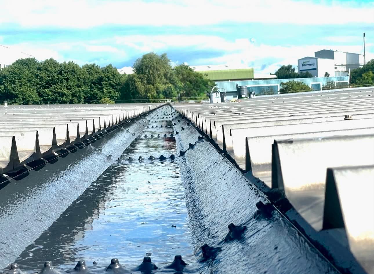 Industrial valley gutter freshly lined with liquid applied waterproofing